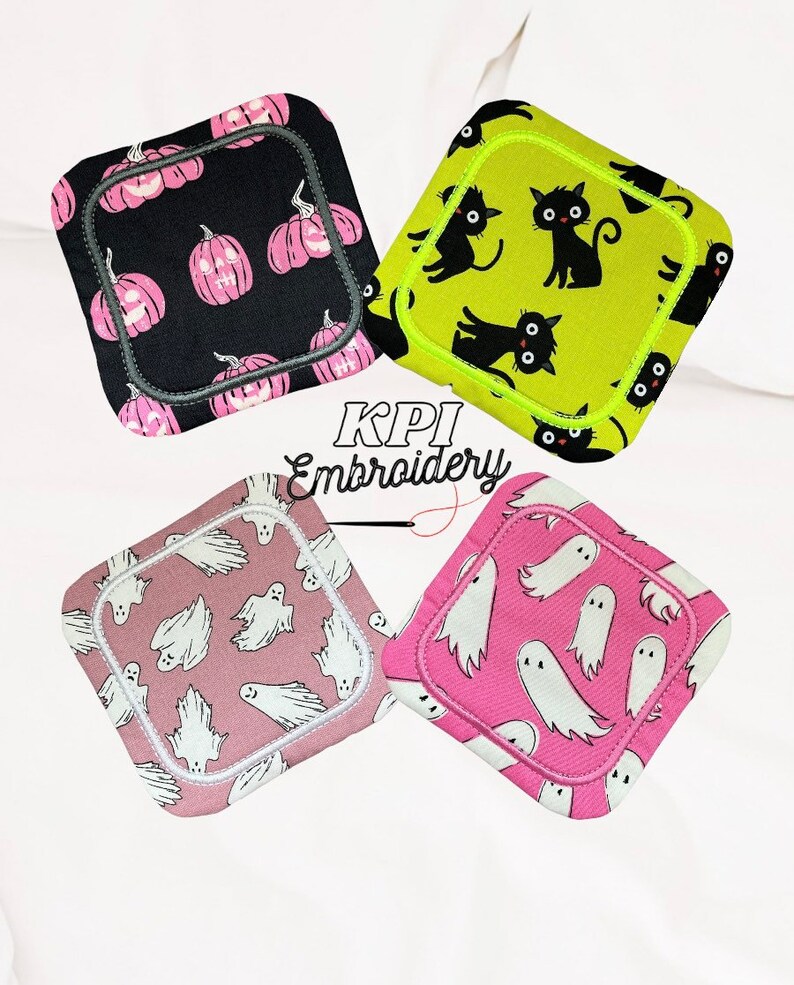 May include: Four square fabric coasters with Halloween designs. One has pink pumpkins on black, another black cats on lime green, and two show white ghosts on pink and mauve backgrounds. The coasters are square.