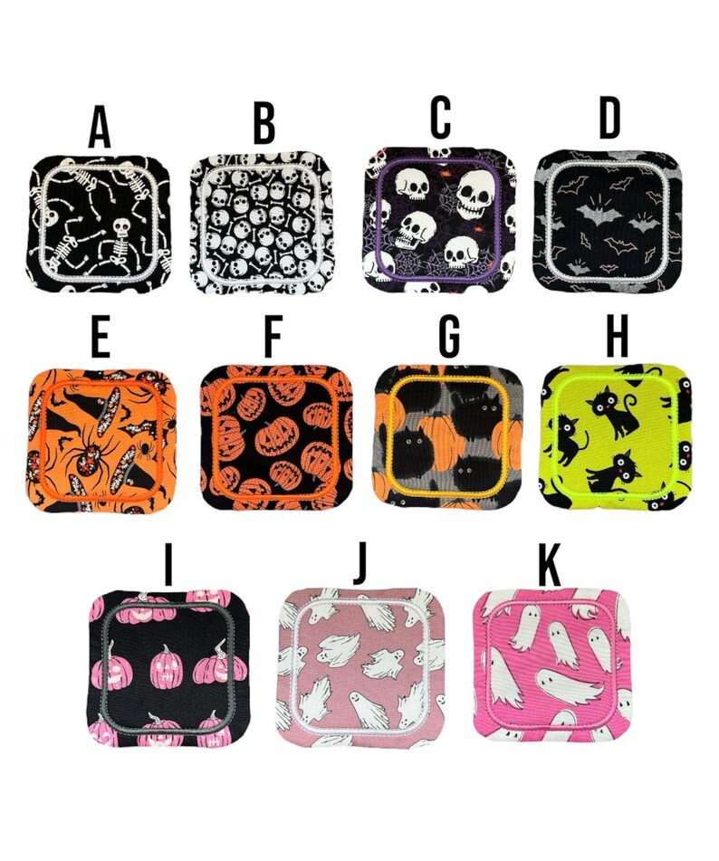 May include: A selection of square fabric coasters with Halloween designs. The coasters display patterns of skeletons, skulls, bats, spiders, pumpkins, and ghosts. They come in a range of colours, including black, orange, pink, and green.