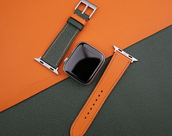May include: Two leather watch bands in orange and green with a black Apple Watch face.