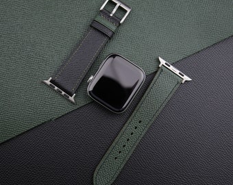 May include: Two green leather watch bands with silver hardware. One band is black with a green stripe, the other is solid green.