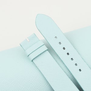May include: Two light blue leather watch straps with multiple holes for adjusting the size.