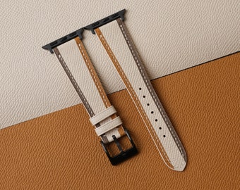 May include: Two white leather watch bands with black stitching and a black buckle. The bands have a striped pattern.