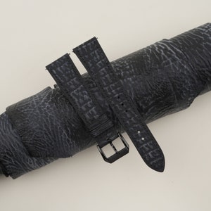 May include: Two black leather watch straps with a textured pattern. The straps have a black buckle and are shown rolled up.