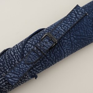 May include: A blue leather watch strap with a black buckle. The strap has a textured pattern that resembles elephant skin.