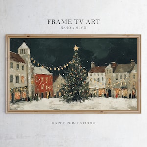 May include: A framed painting of a snowy Christmas scene. Buildings with lit windows and string lights surround a decorated Christmas tree. The artwork has a dark background and the text "FRAME TV ART" and "HAPPY PRINT STUDIO".