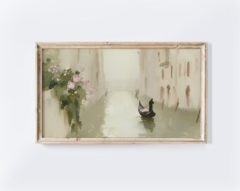May include: A framed oil painting depicts a Venetian canal scene. The artwork features a gondola, buildings, and pink flowers. The painting is in a light color palette with a distressed wooden frame.