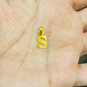 以下が含まれることがあります： 「S」の文字の形をした金色のペンダント