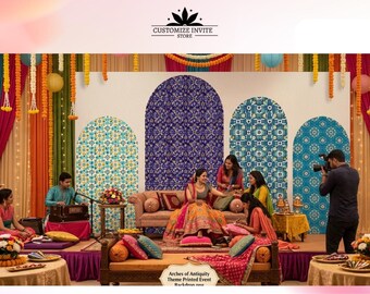 May include: A large event backdrop featuring four distinct arched panels with intricate blue and white geometric patterns. The display is framed by colorful fabric drapes in orange, green, and pink, with hanging marigold garlands and paper lanterns.