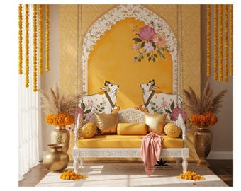 May include: A decorative yellow and white bench with floral and cow motifs. The bench is adorned with gold pillows and a pink cloth. The background features a yellow wall with floral accents and hanging marigold garlands.