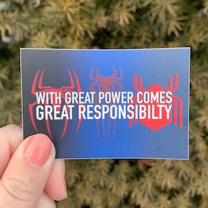 Può includere: Un adesivo blu e nero con tre silhouette rosse di Spider-Man e il testo "With great power comes great responsibility."