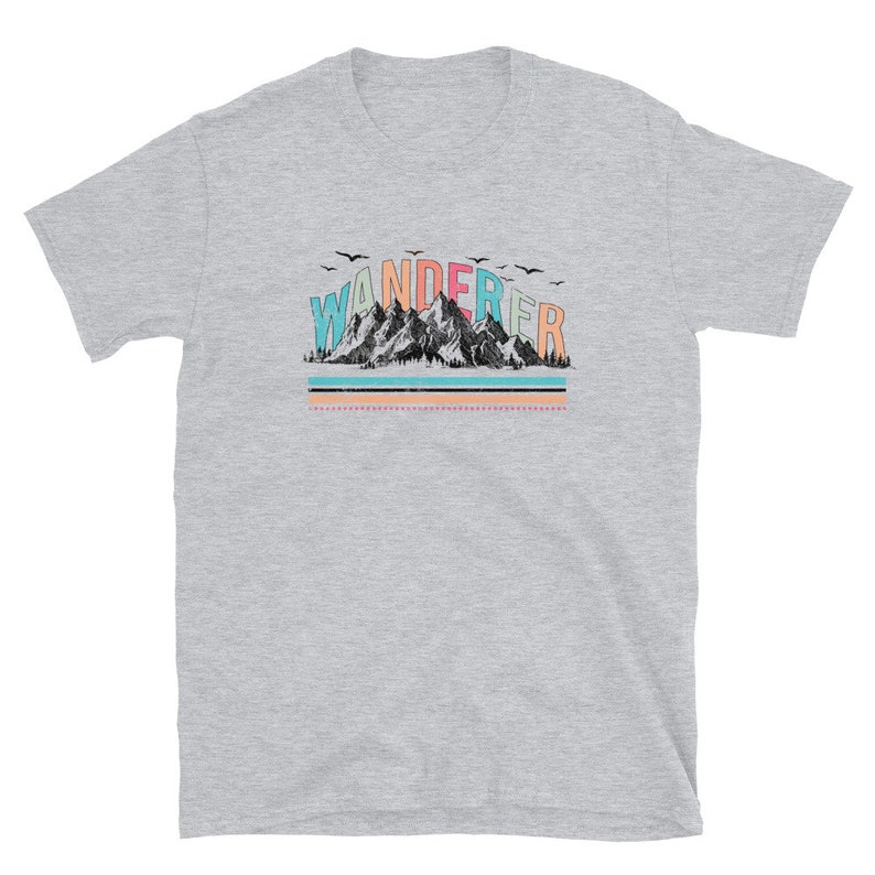 May include: A grey short-sleeved t-shirt with a graphic of mountains and the word "WANDERER" in rainbow colors.