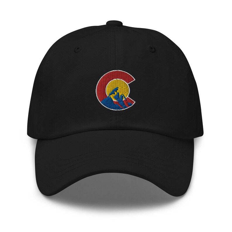 Puede incluir: Gorra de b&eacute;isbol negra con un logotipo bordado del estado de Colorado que presenta un sol amarillo, monta&ntilde;as rojas y azules y un contorno blanco. El logotipo est&aacute; centrado en la parte delantera de la gorra.