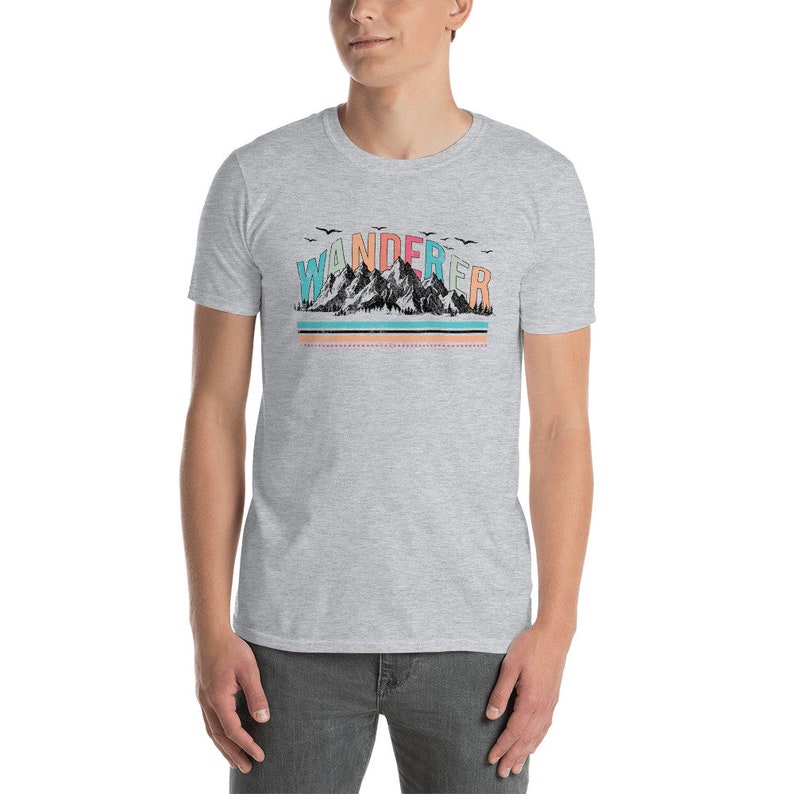 May include: A heather grey t-shirt with a graphic of a mountain range and the word "WANDERER" in colorful letters.