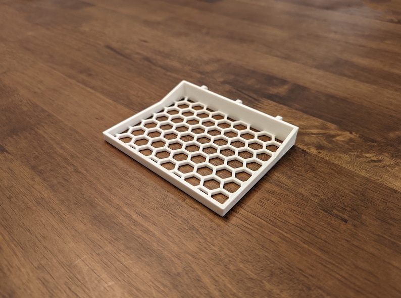 May include: White plastic tray with a honeycomb pattern. The tray is slightly curved and has a raised edge.