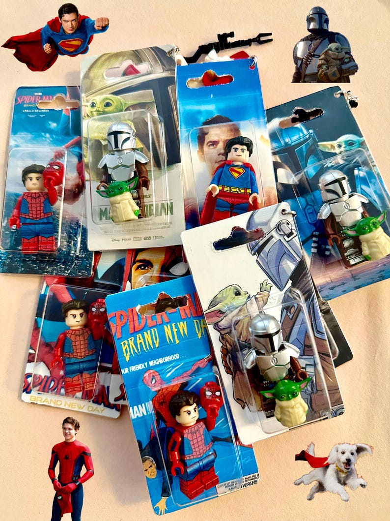 Op de afbeelding: Een verzameling actiefiguurtjes met personages uit Spider-Man, Superman en The Mandalorian. De figuren zitten in hun originele verpakking, met levendige kleuren en gedetailleerde ontwerpen. De afbeelding bevat een vliegende Superman en een hond met een cape.