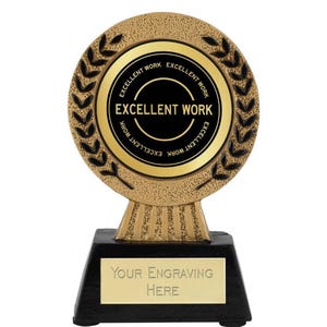 Könnte beinhalten: Goldfarbener Pokal mit schwarzem Sockel. Der Pokal hat eine runde Oberseite mit einem Lorbeerkranz-Design und die Worte "Excellent Work" in goldenen Buchstaben auf schwarzem Hintergrund. Der Sockel hat eine goldene Plakette mit dem Text "Your Engraving Here".