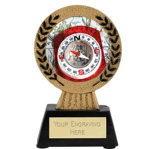 Könnte beinhalten: Goldene Kompass-Trophäe mit einem roten und weißen Kompass-Zifferblatt und einem schwarzen Sockel mit dem Text "YOUR ENGRAVING HERE".