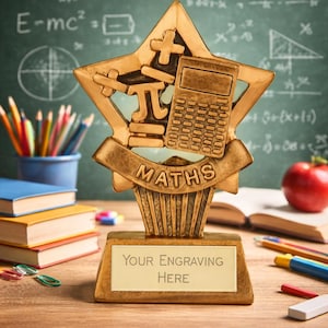 May include: A gold trophy with a star-shaped top, displaying math symbols and a calculator. The base reads "MATHS" and has space for engraving. The background features a chalkboard with equations, books, pencils, and an apple.