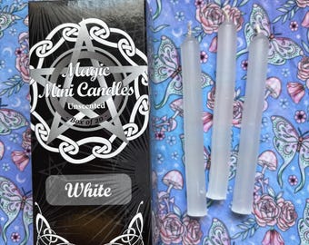 May include: A box of 20 white unscented mini candles. The box has a black background with a white pentagram and the words "Magic Mini Candles" and "White".