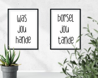 Op de afbeelding: Twee ingelijste prints met zwarte lijsten en witte achtergronden. De print aan de linkerkant zegt "was jou hande" en de print aan de rechterkant zegt "borsel jou tande".