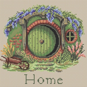 Può includere: Ricamo a punto croce di una porta verde di hobbit con una finestra rotonda e un telaio rosso, circondata da vegetazione lussureggiante e fiori viola. Una piccola carriola marrone è davanti alla porta, con la parola "Home" ricamata sotto.