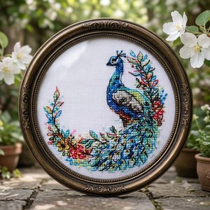 May include: A circular cross-stitch embroidery featuring a peacock with blue, green, and gold plumage, surrounded by a colorful floral wreath on white fabric, encased in an ornate, dark bronze-toned circular frame with intricate detailing.