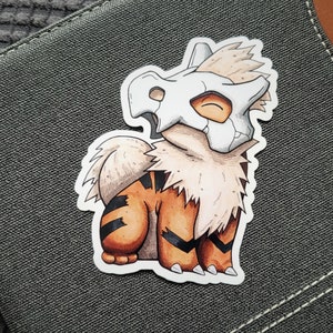 Puede incluir: Una ilustraci&oacute;n de dibujos animados de un Pok&eacute;mon marr&oacute;n y blanco con un casco blanco en forma de cr&aacute;neo. El Pok&eacute;mon est&aacute; sentado sobre sus patas traseras con sus patas delanteras apoyadas en el suelo. El Pok&eacute;mon tiene una cola rayada de marr&oacute;n y blanco.