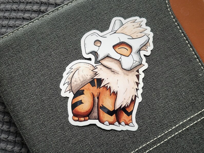 Puede incluir: Una ilustraci&oacute;n de dibujos animados de un Pok&eacute;mon marr&oacute;n y blanco con un casco blanco en forma de cr&aacute;neo. El Pok&eacute;mon est&aacute; sentado sobre sus patas traseras con sus patas delanteras apoyadas en el suelo. El Pok&eacute;mon tiene una cola rayada de marr&oacute;n y blanco.