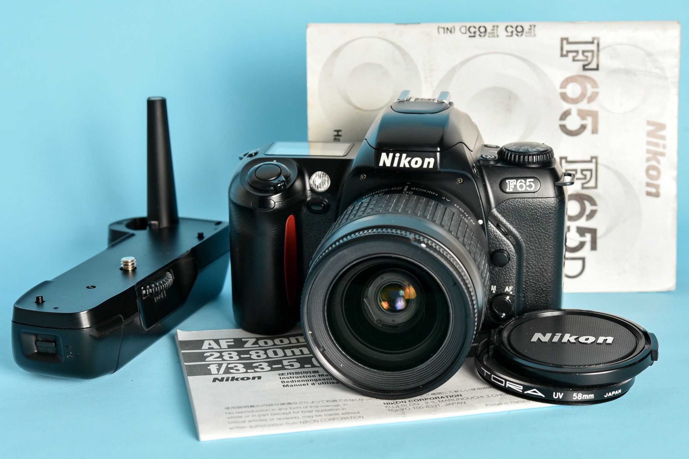 Nikon F65 con lente Nikkor de 28-80 mm y paquete de batería