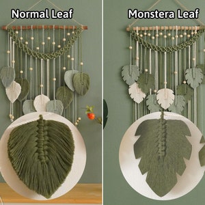 May include: Two macrame wall hangings with different leaf shapes. The left one is labeled "Normal Leaf" and the right one is labeled "Monstera Leaf". Both hangings feature a wooden dowel rod, white and green yarn, and small wooden beads.