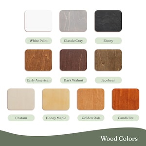 May include: A collection of wood color samples, each in a rectangular shape with rounded corners. The colors range from white and gray to various shades of brown and orange. Text labels identify each color, including "White Paint," "Ebony," and "Golden Oak."