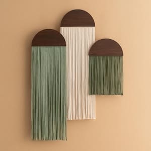 May include: Three wall hangings with wooden half-circle tops and long strands of yarn. The largest hanging has cream-colored yarn, the middle hanging has green yarn, and the smallest hanging has green yarn.