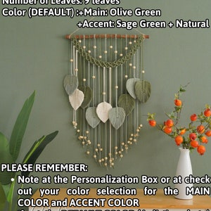 May include: A macrame wall hanging with nine leaves in olive green and sage green colors. The leaves are made of yarn and are attached to a wooden dowel. The wall hanging is decorated with wooden beads. The text "EXAMPLE VARIATION (AS PHOTO BELOW)" is at the top of the image. The text "Number of Leaves: 9 leaves" is below the first line of text. The text "Color (DEFAULT) :+Main: Olive Green +Accent: Sage Green + Natural" is below the second line of text. The text "PLEASE REMEMBER: Note at the Personalization Box or at check out your color selection for the MAIN COLOR and ACCENT COLOR If not, the DEFAULT COLOR (in listing photo) will be applied." is at the bottom of the image.