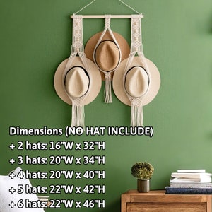 May include: Macrame hat holder with a wooden dowel and hanging rope, designed to hold multiple hats. The dimensions are listed in the image. The holder is displayed against a green wall, with three hats hanging from it.