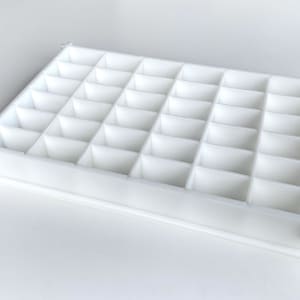 Può includere: Vassoio di stoccaggio in plastica bianca con 36 scomparti.