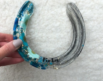 A resin horseshoe keepsake which is custom made using horse hair and flowers etc. Makes a perfect equine Christmas gift and stocking filler