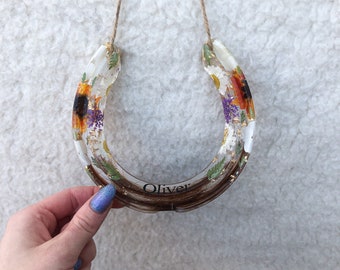 A resin horseshoe keepsake which is custom made using horse hair and flowers etc. Makes a perfect equine Christmas gift and stocking filler