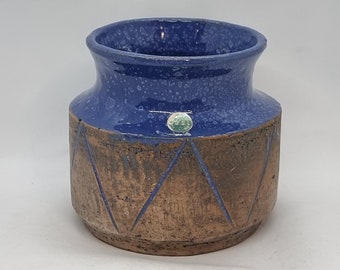 May include: A blue and brown ceramic vase with a geometric pattern. The vase has a speckled blue glaze and a brown glaze with a diamond pattern.