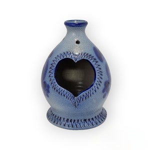 May include: A blue and white ceramic heart-shaped incense burner with a decorative blue trim.