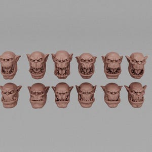May include: Twelve unpainted miniature orc heads with different expressions, each with a distinct set of teeth and a prominent brow.