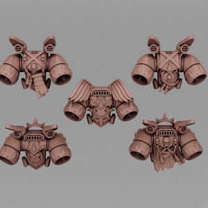 May include: A set of five brown resin miniature jump packs for tabletop gaming figures. Each unit features dual thrusters, mechanical details, and gothic ornamentation including skulls, chains, scrolls, and wings on the central pack.