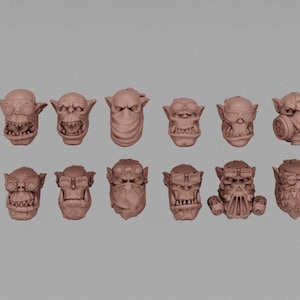 May include: A collection of twelve brown, stylized miniature Orc heads. Each head features unique details, including goggles, bandanas, and gas masks. The heads are arranged in two rows against a neutral background, showcasing various expressions and accessories.