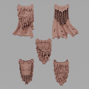 May include: Five miniature, tan-colored fantasy armor pieces are displayed against a neutral background. The collection includes two capes with textured edges, two chest pieces with intricate details, and one additional cape with a chainmail design.