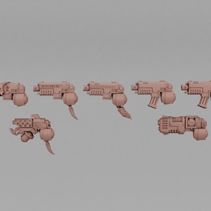 May include: A collection of seven beige-colored, futuristic-looking toy guns. Each gun has a unique design, with details like textured surfaces, mechanical attachments, and some with text. The guns are arranged against a plain background.