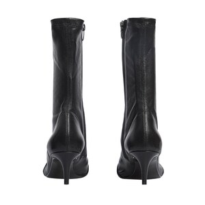 Pu&ograve; includere: Stivali da caviglia in pelle nera con punta a punta e tacco a stiletto.