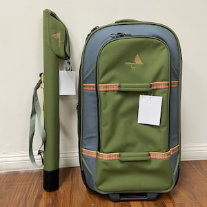 May include: A green and gray rolling suitcase with a fly fishing logo and a matching green fly rod case with a strap.
