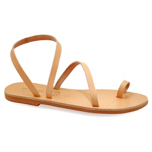 May include: Tan leather sandals with a single strap that wraps around the ankle and toe. The sandals have a flat sole and are made in Greece.