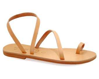 May include: Tan leather sandals with a single strap that wraps around the ankle and toe. The sandals have a flat sole and are made in Greece.