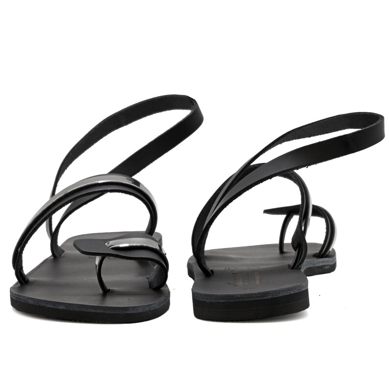 May include: Black leather sandals with a silver buckle and a strap that goes around the ankle.