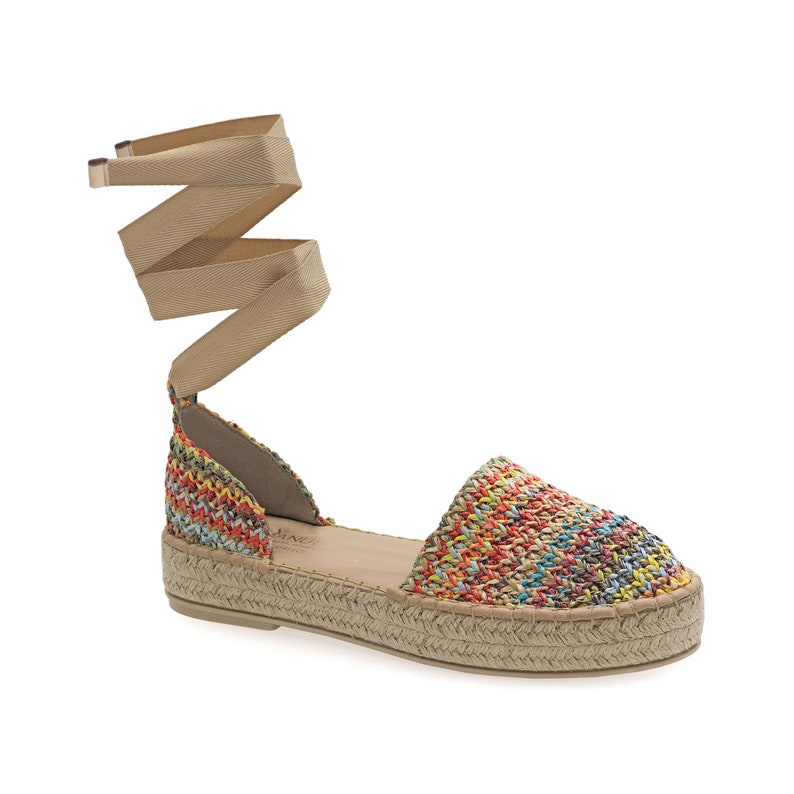May include: Espadrille sandals with a woven multi-color upper and a beige ankle wrap. The sole is made of woven jute. The sandals have a low platform and a rounded toe.